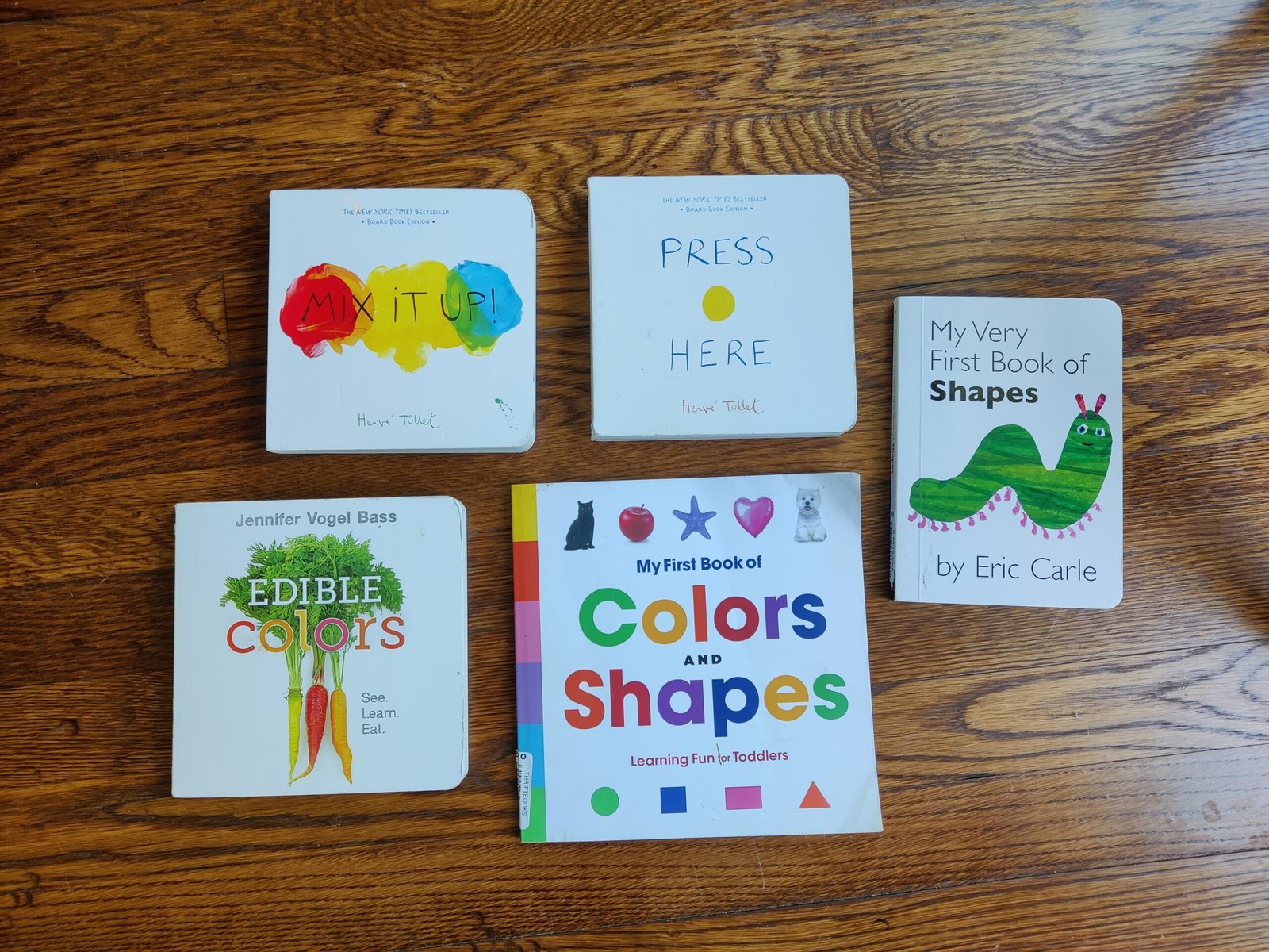 Toddler books about shapes and colors arranged on a table