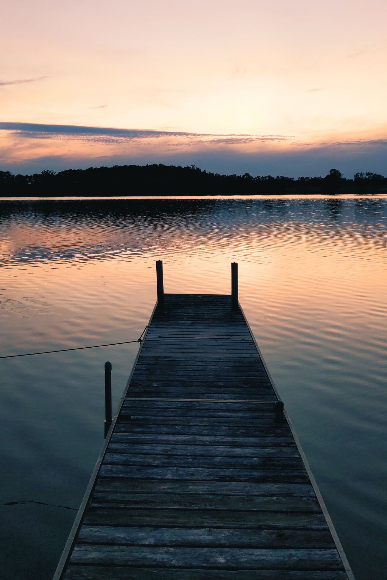 a dock with a sunset behind